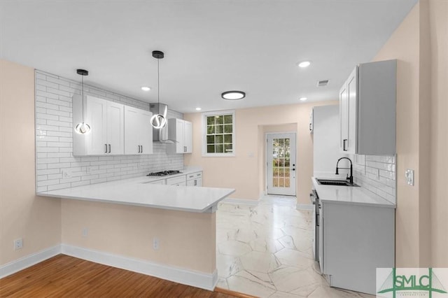 kitchen with baseboards, visible vents, light countertops, and a sink