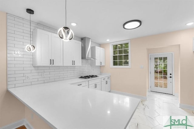 kitchen featuring white cabinetry, marble finish floor, backsplash, wall chimney exhaust hood, and stainless steel gas stovetop