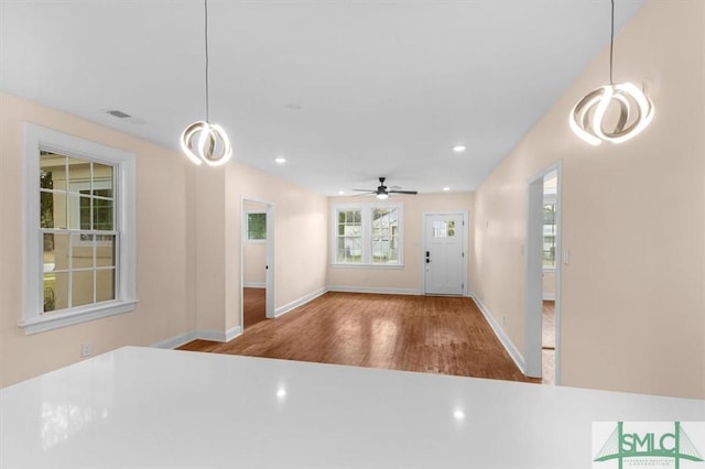 foyer entrance featuring baseboards, wood finished floors, visible vents, and recessed lighting