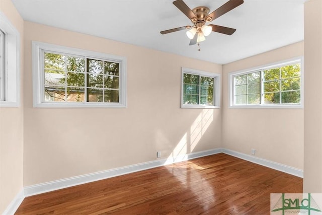 unfurnished room featuring a ceiling fan, baseboards, and wood finished floors