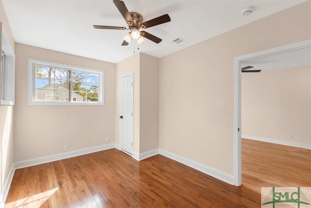 unfurnished bedroom with baseboards, visible vents, ceiling fan, and wood finished floors