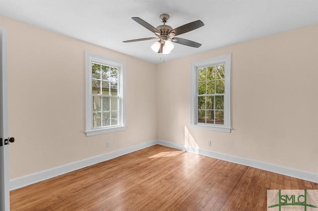 empty room with a ceiling fan, baseboards, and wood finished floors