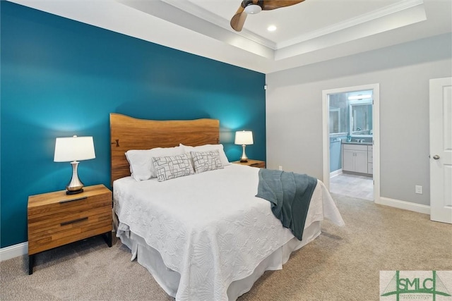 carpeted bedroom with recessed lighting, a raised ceiling, ensuite bath, and baseboards