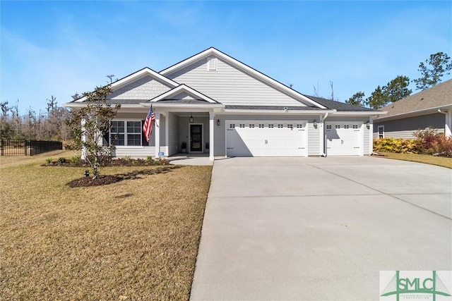 view of front of home with a front yard, concrete driveway, fence, and an attached garage