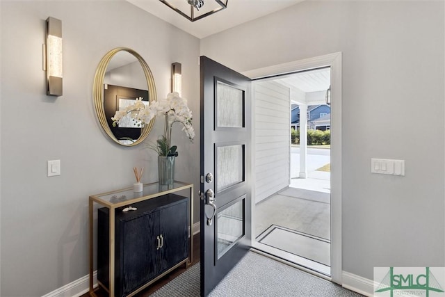 carpeted foyer entrance featuring baseboards