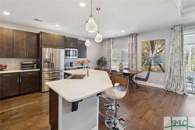 kitchen featuring visible vents, dark wood-style floors, appliances with stainless steel finishes, light countertops, and a sink