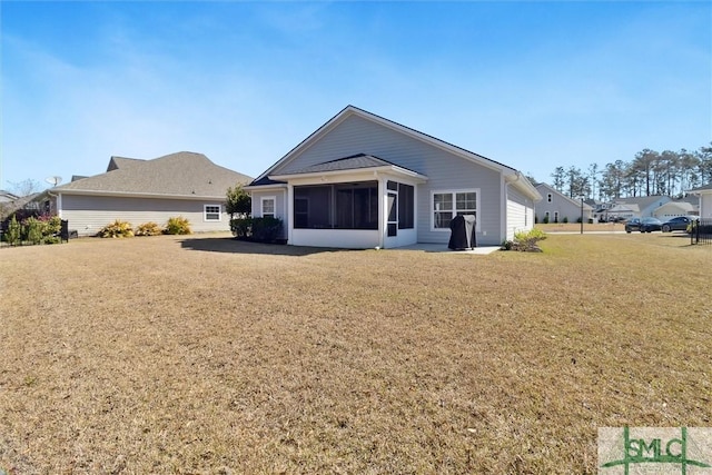 back of property featuring a lawn and a sunroom