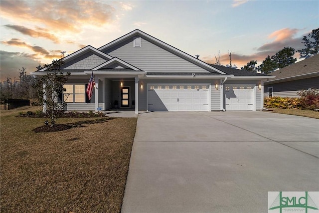 view of front facade with concrete driveway, a yard, and an attached garage