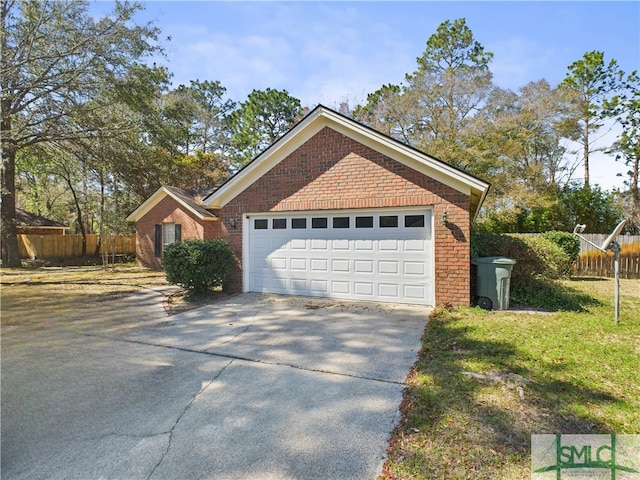 view of front of home with driveway, an attached garage, fence, and brick siding