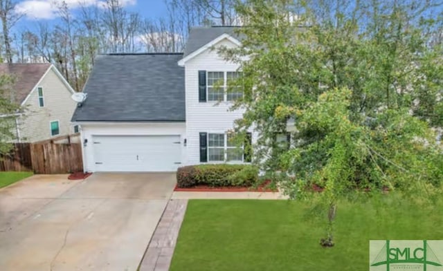 view of front of home with an attached garage, fence, concrete driveway, and a front yard