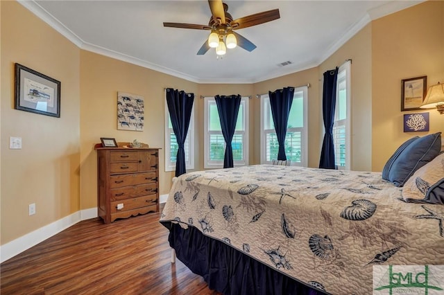 bedroom with baseboards, visible vents, ceiling fan, wood finished floors, and crown molding