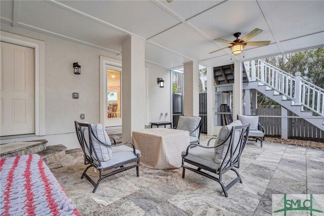 view of patio with stairs, fence, outdoor dining area, and a ceiling fan