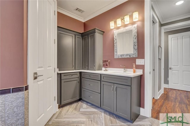 bathroom featuring baseboards, visible vents, crown molding, and vanity