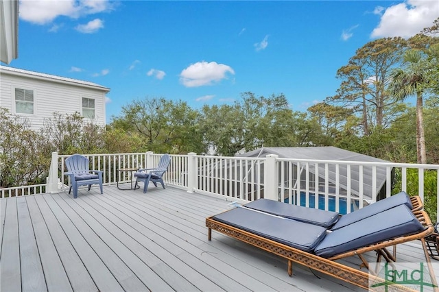 wooden deck featuring a lanai and a swimming pool