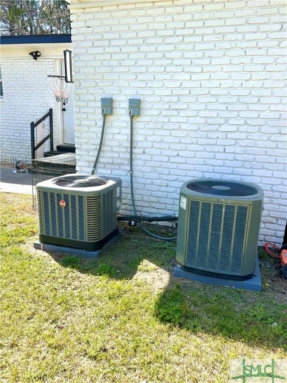 exterior details featuring central air condition unit and brick siding