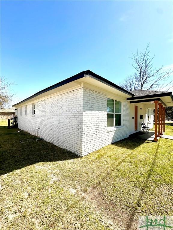 view of home's exterior with a yard and brick siding