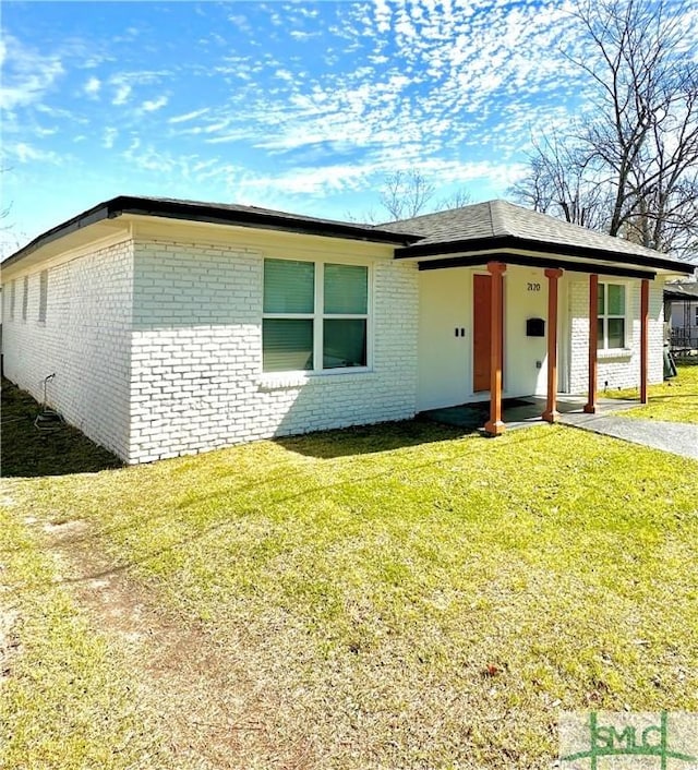 single story home with a front yard and brick siding