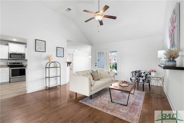 living area with high vaulted ceiling, wood finished floors, a ceiling fan, and baseboards