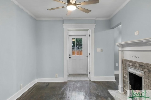 unfurnished living room featuring a brick fireplace, baseboards, ornamental molding, and wood finished floors