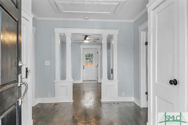 foyer entrance with crown molding, ceiling fan, dark wood finished floors, and ornate columns