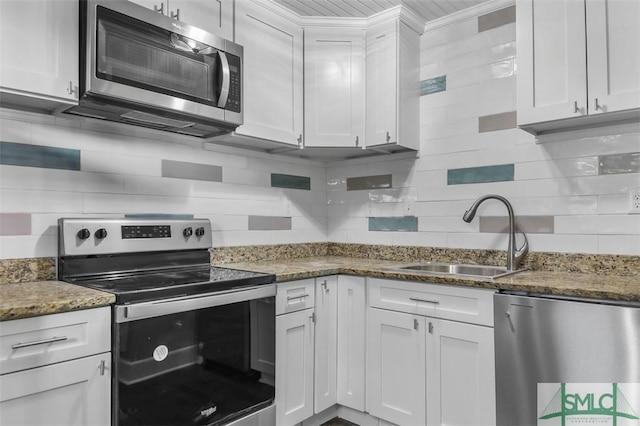 kitchen featuring stainless steel appliances, white cabinets, a sink, and tasteful backsplash