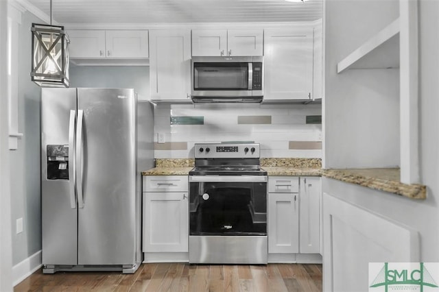 kitchen with appliances with stainless steel finishes, white cabinets, and wood finished floors