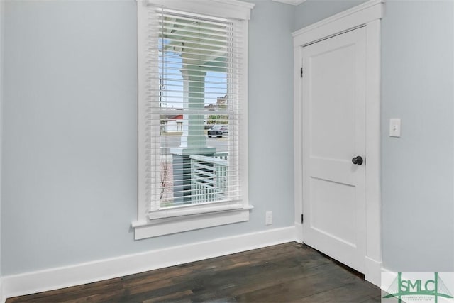 interior space featuring dark wood-type flooring and baseboards