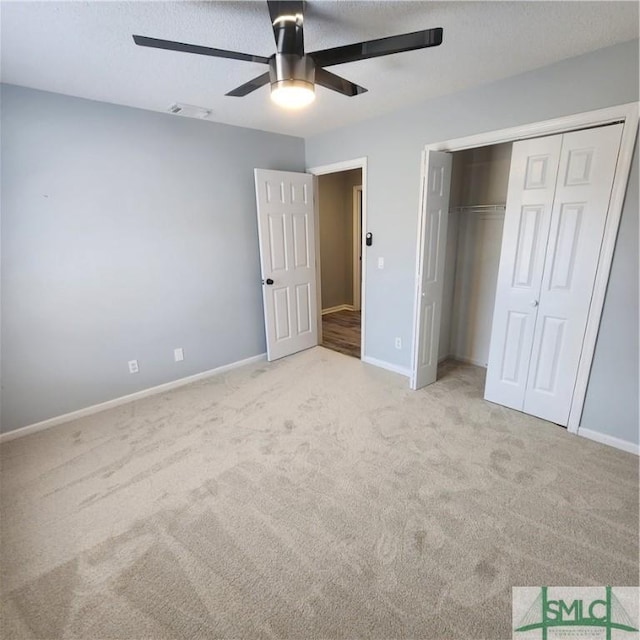 unfurnished bedroom featuring baseboards, visible vents, carpet floors, and a closet