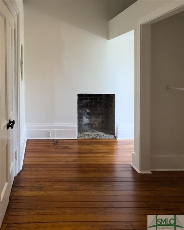 unfurnished living room with baseboards, a fireplace, and hardwood / wood-style flooring