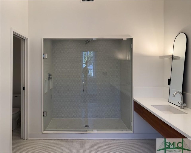 bathroom featuring vanity, a shower stall, toilet, and visible vents