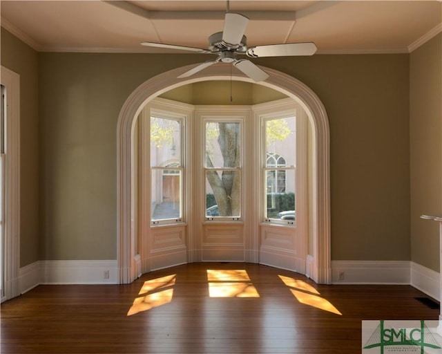 unfurnished room featuring ceiling fan, crown molding, baseboards, and wood finished floors