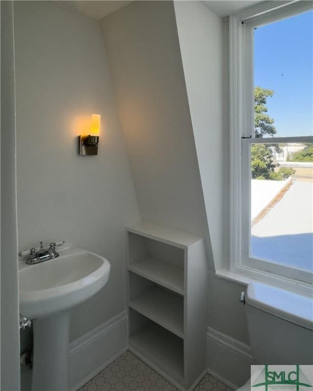 half bathroom with toilet and baseboards