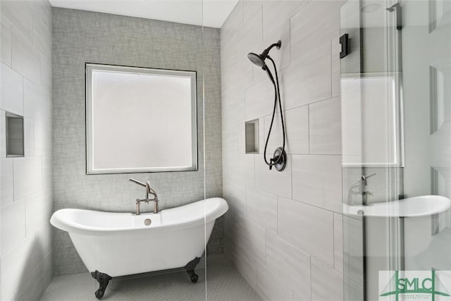 bathroom with tile walls, a freestanding bath, and a shower stall