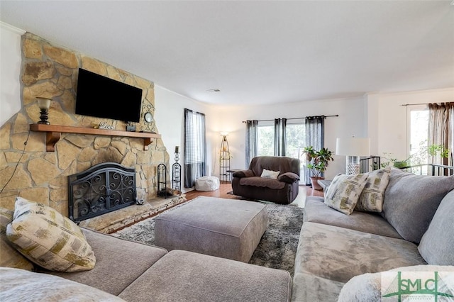 living area with a stone fireplace and wood finished floors