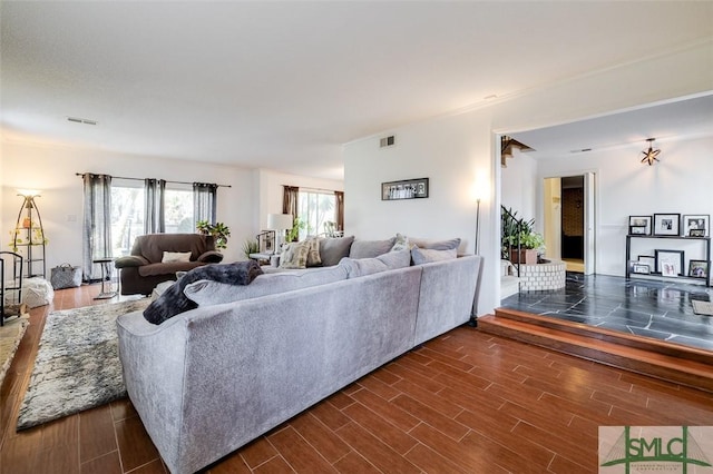 living area featuring visible vents and wood finish floors