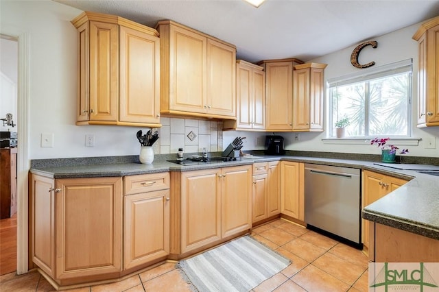 kitchen featuring dark countertops, cooktop, light brown cabinets, and stainless steel dishwasher