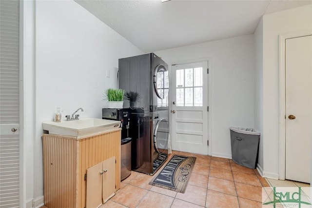 kitchen with stacked washer and dryer, light countertops, light tile patterned flooring, and baseboards