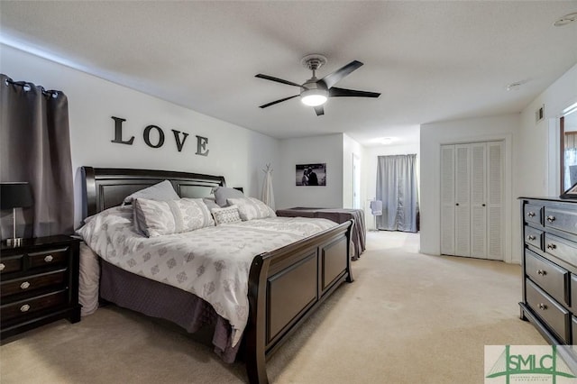 bedroom featuring visible vents, a closet, a ceiling fan, and light colored carpet