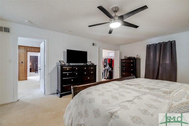 bedroom with a closet, visible vents, a spacious closet, light carpet, and ceiling fan