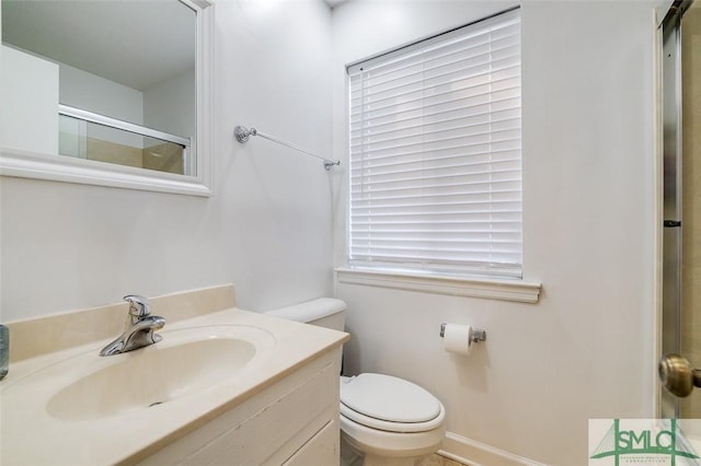 bathroom with vanity, an enclosed shower, and toilet