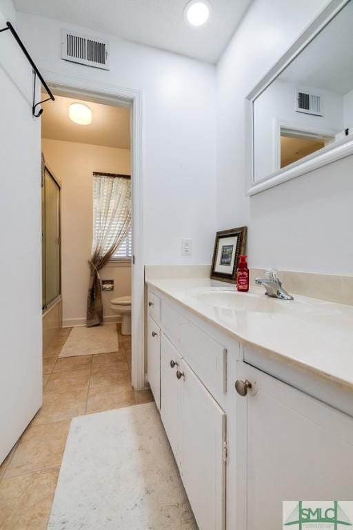 bathroom featuring toilet, tile patterned floors, visible vents, and vanity