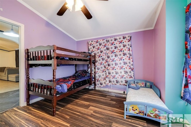 bedroom featuring vaulted ceiling, crown molding, and wood finished floors