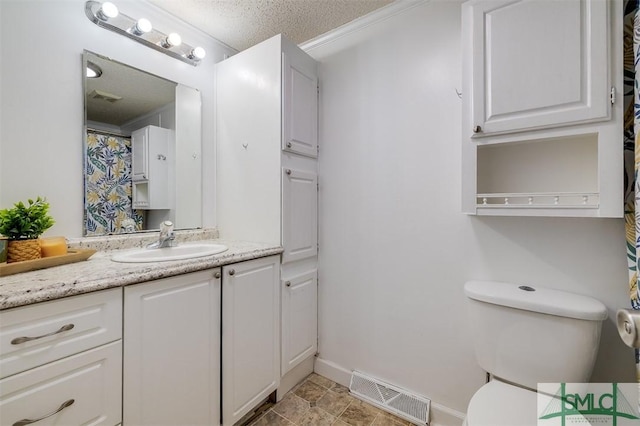 bathroom featuring toilet, visible vents, a textured ceiling, and vanity