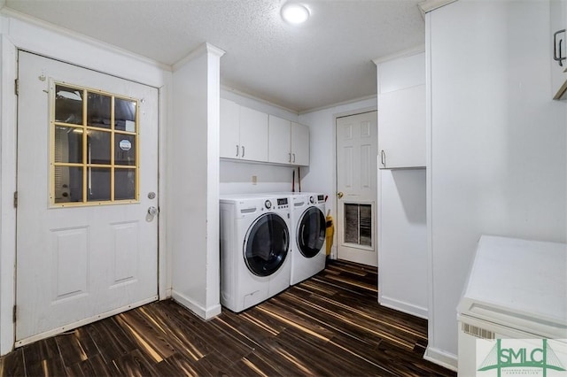 laundry area with cabinet space, ornamental molding, dark wood-style flooring, and washing machine and clothes dryer