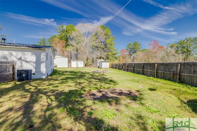 view of yard featuring central AC, a shed, an outdoor structure, and a fenced backyard