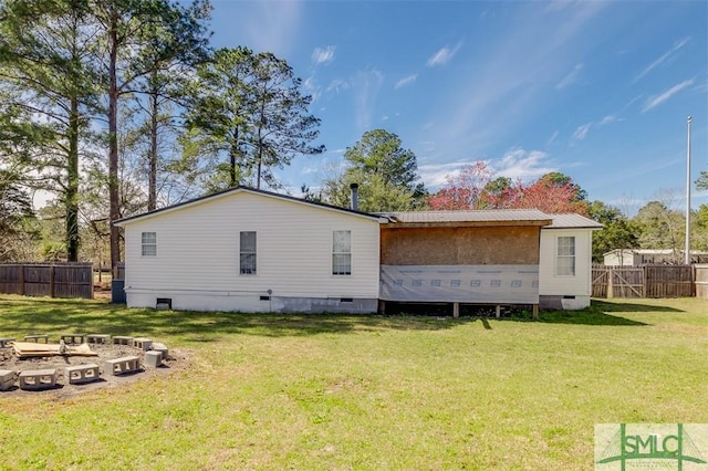 rear view of property with crawl space, a yard, and fence