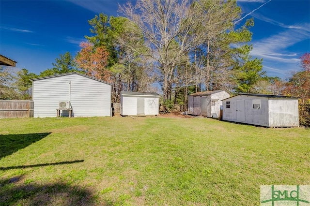 view of yard featuring a storage unit, an outdoor structure, and fence