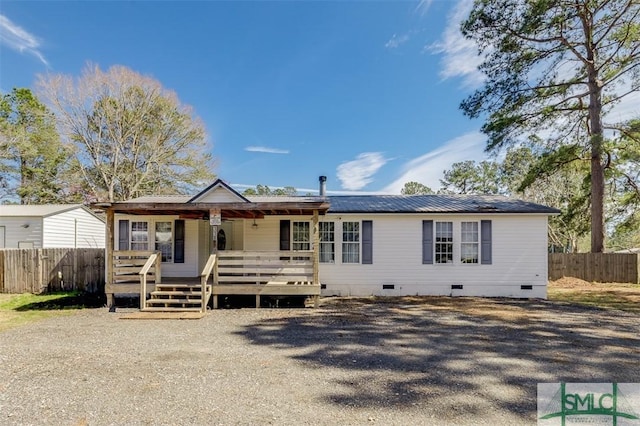 ranch-style home featuring crawl space, fence, and metal roof