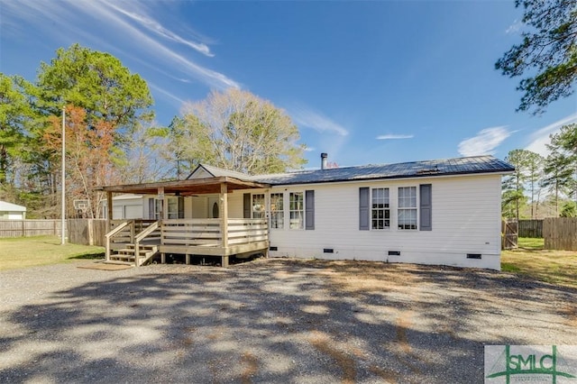 ranch-style home featuring crawl space, fence, metal roof, and a wooden deck