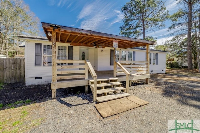 view of front of house with crawl space, fence, metal roof, and a wooden deck